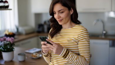 mujer revisando su teléfono en casa