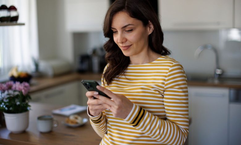 mujer revisando su teléfono en casa