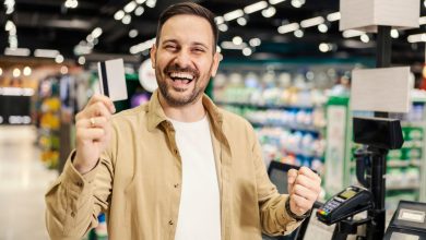 hombre feliz pagando con tarjeta el súper