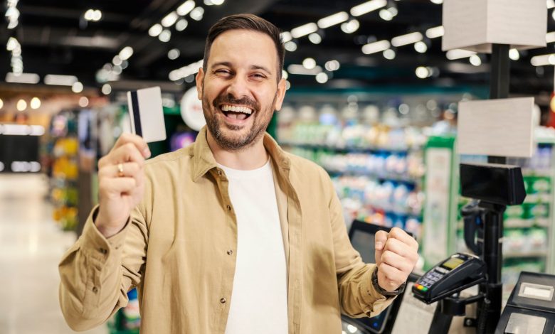 hombre feliz pagando con tarjeta el súper