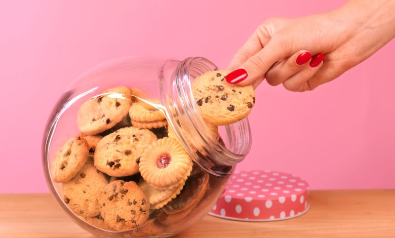 mano femenina tomando galletas de un jarrón