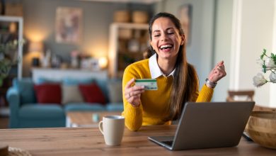 mujer sonriente haciendo un pago con tarjeta