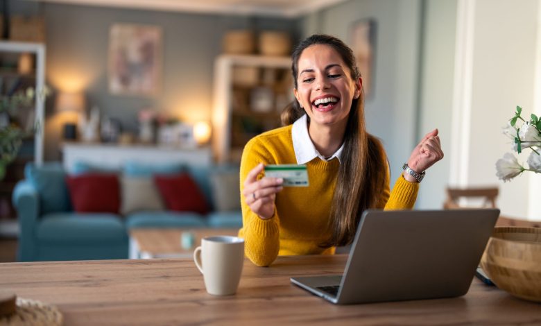 mujer sonriente haciendo un pago con tarjeta