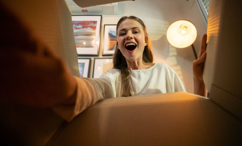 mujer sonriente abriendo una caja de regalo